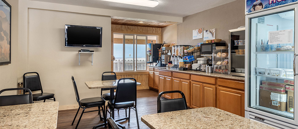 A breakfast area stocked with cereals, juices, beverages, and pastries. 