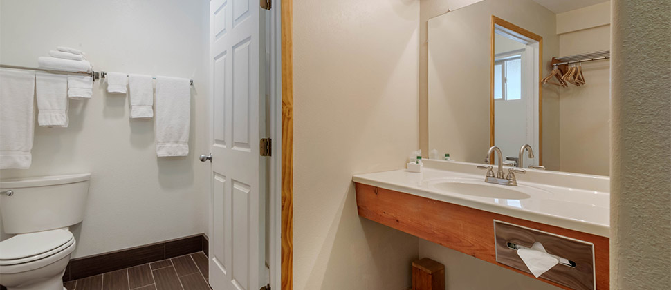 Stand alone sink with full size mirror and entry into the commode. 