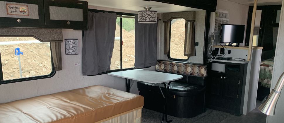 View of dining area with light above, leather furniture, flat-screen TV, and view of bedroom